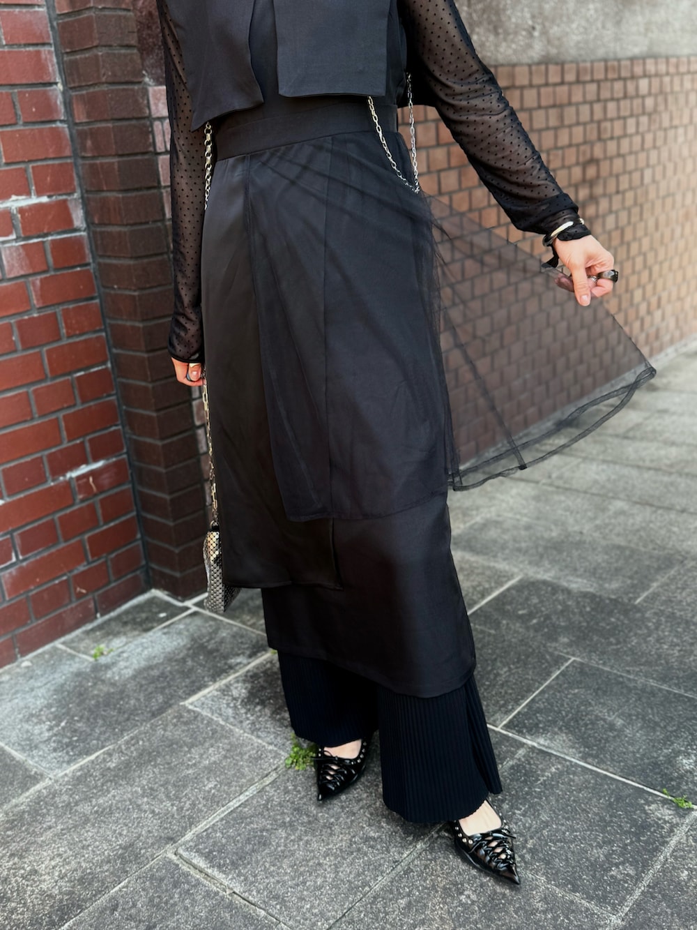 ブラック系のパンプス、グレー系のハンドバッグ、ブラック系のその他パンツを着用したレディースの春コーディネートの3枚目の写真