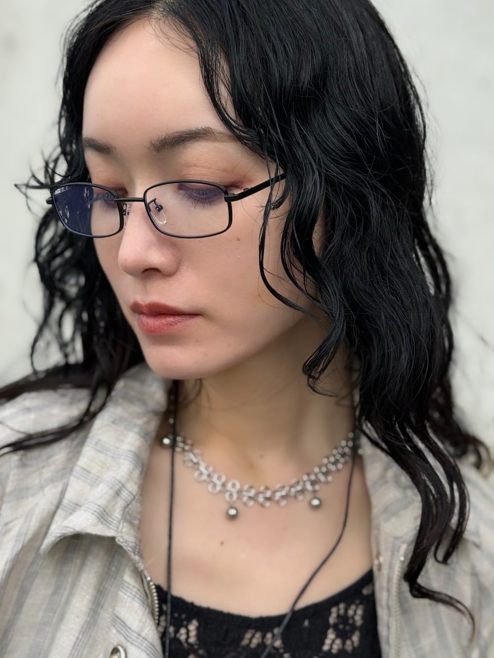 ブラック系のタンクトップ、ブルー系のサンダル、グレー系のトレンチコートを着用したレディースの春コーディネートの2枚目の写真