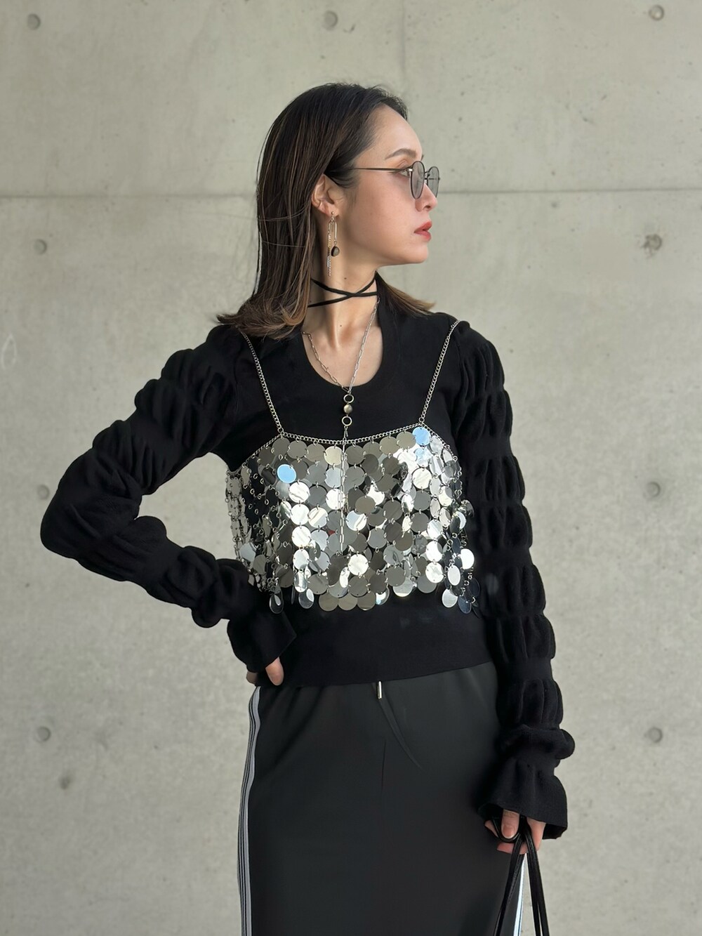 ブラック系のパンプス、シルバー系のハンドバッグ、ブラック系のスカートを着用したレディースの春コーディネートの3枚目の写真