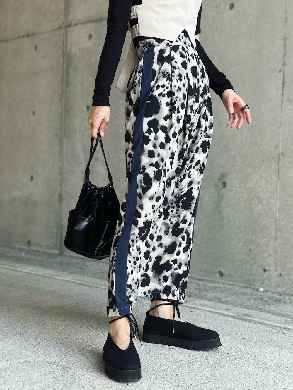 ブラック系のスカート、ホワイト系のキャミソール、ブラック系のTシャツ/カットソーを着用したレディースの秋コーディネートの2枚目の写真