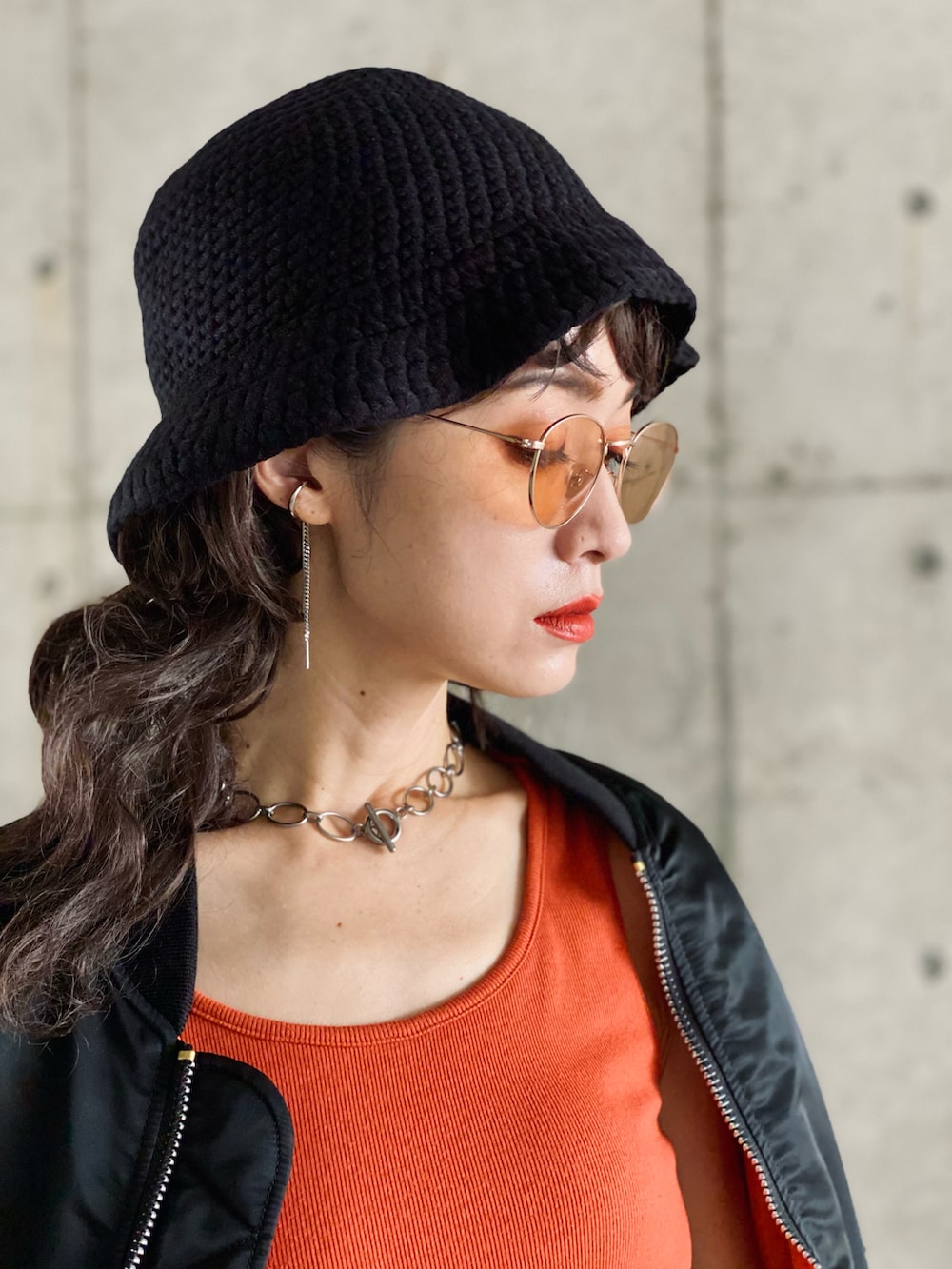 ブラック系のMA-1、ブルー系のデニムスカート、オレンジ系のタンクトップを着用したレディースの秋コーディネートの2枚目の写真