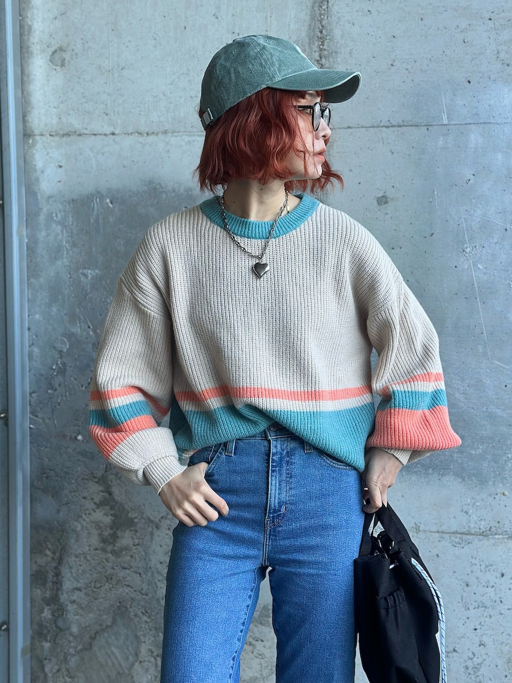 ホワイト系のニット/セーター、ブルー系のデニムパンツ、グリーン系のミリタリージャケットを着用したレディースの冬コーディネートの3枚目の写真