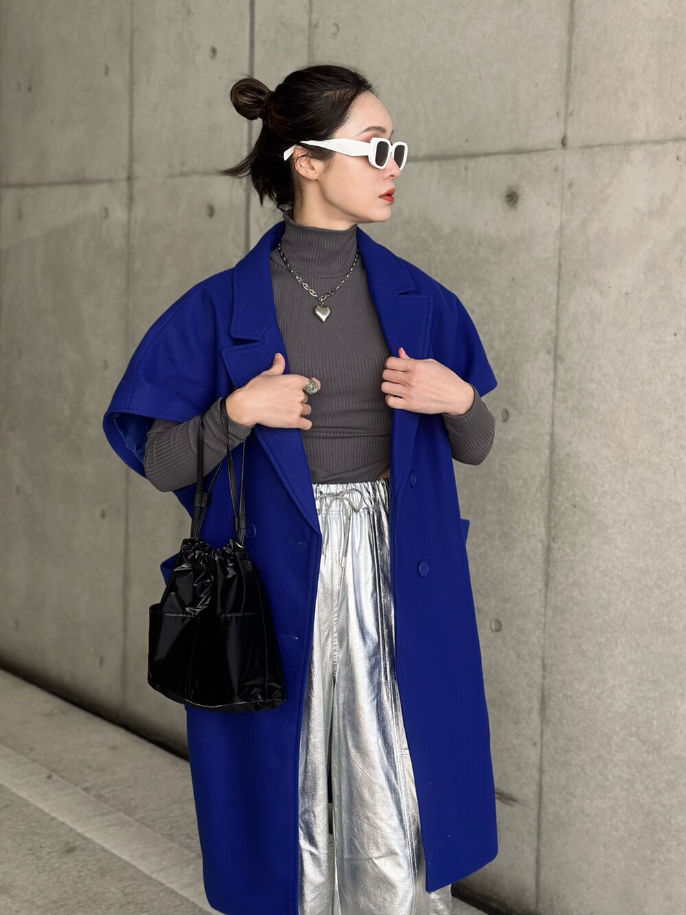 ブラック系のハンドバッグ、シルバー系のその他パンツ、ブルー系のチェスターコートを着用したレディースの冬コーディネートの5枚目の写真