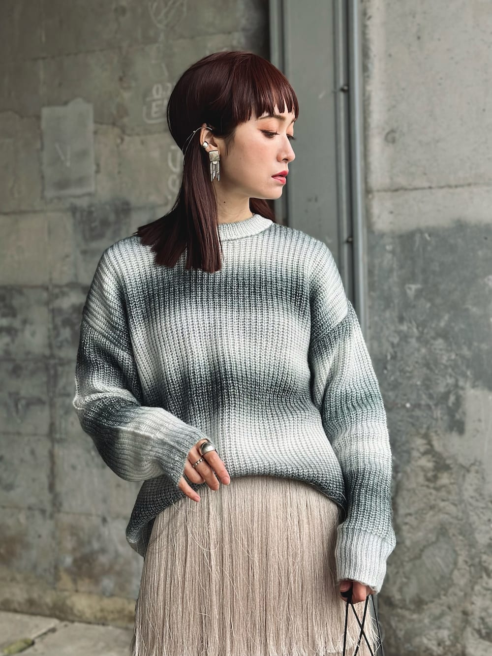 ホワイト系のブーツ、ブラック系のニット/セーター、ホワイト系のスカートを着用したレディースの冬コーディネートの3枚目の写真