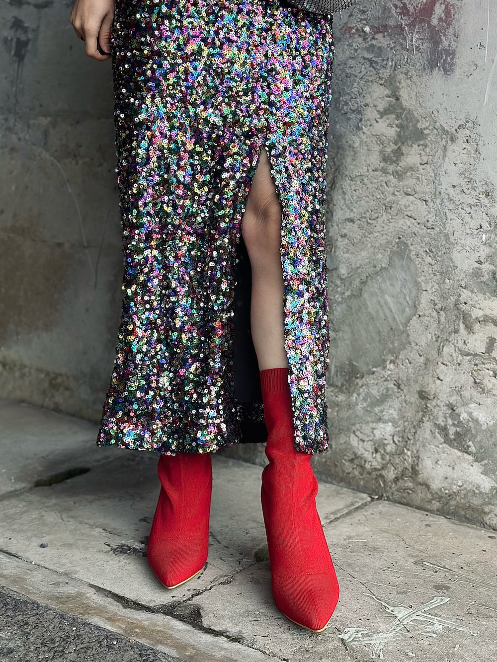 レッド系のニット/セーター、レッド系のブーツ、その他のスカートを着用したレディースの冬コーディネートの5枚目の写真