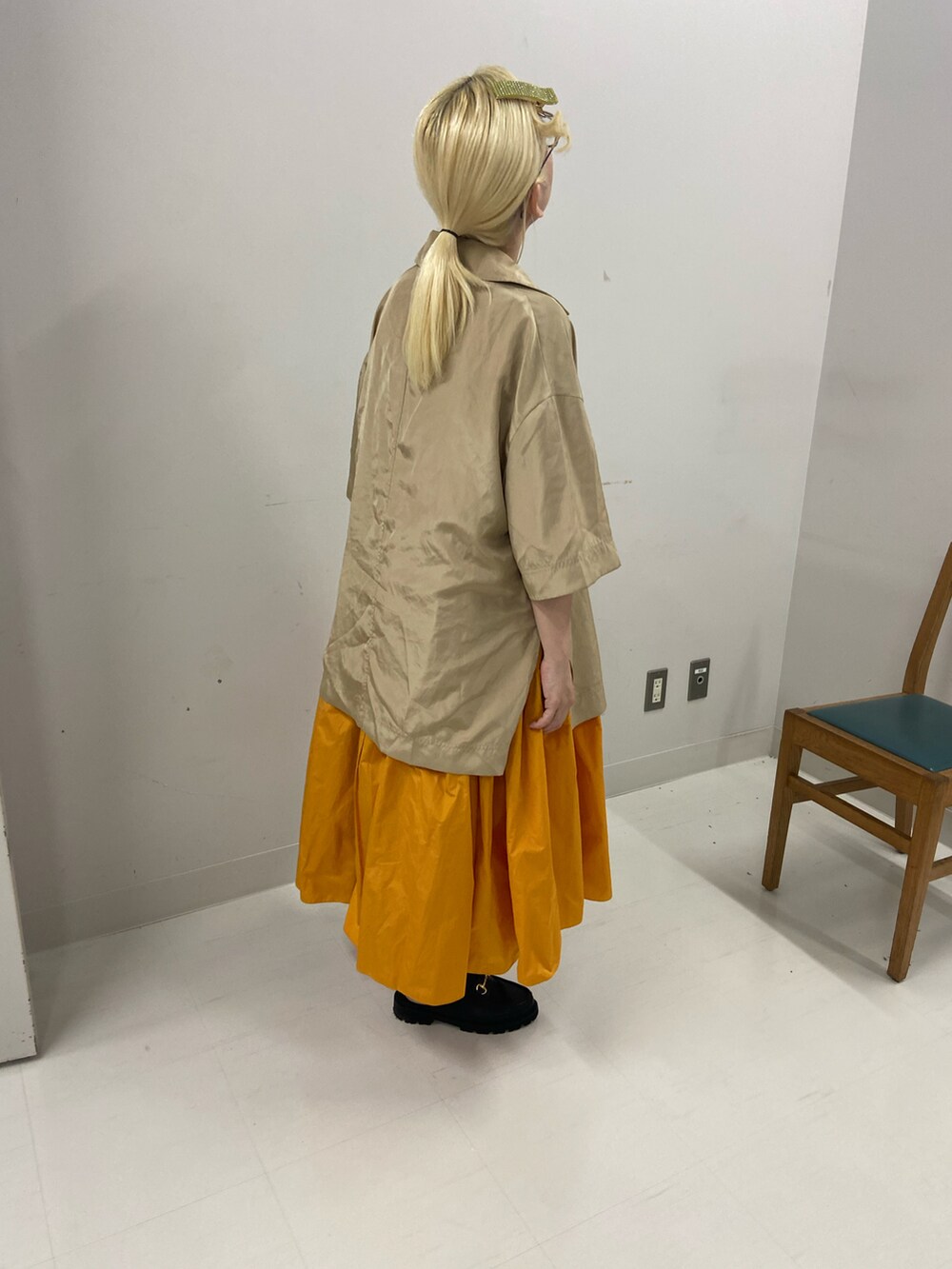 ベージュ系のテーラードジャケット、イエロー系のドレス、ブラック系のサンダルを着用したレディースの夏コーディネートの2枚目の写真