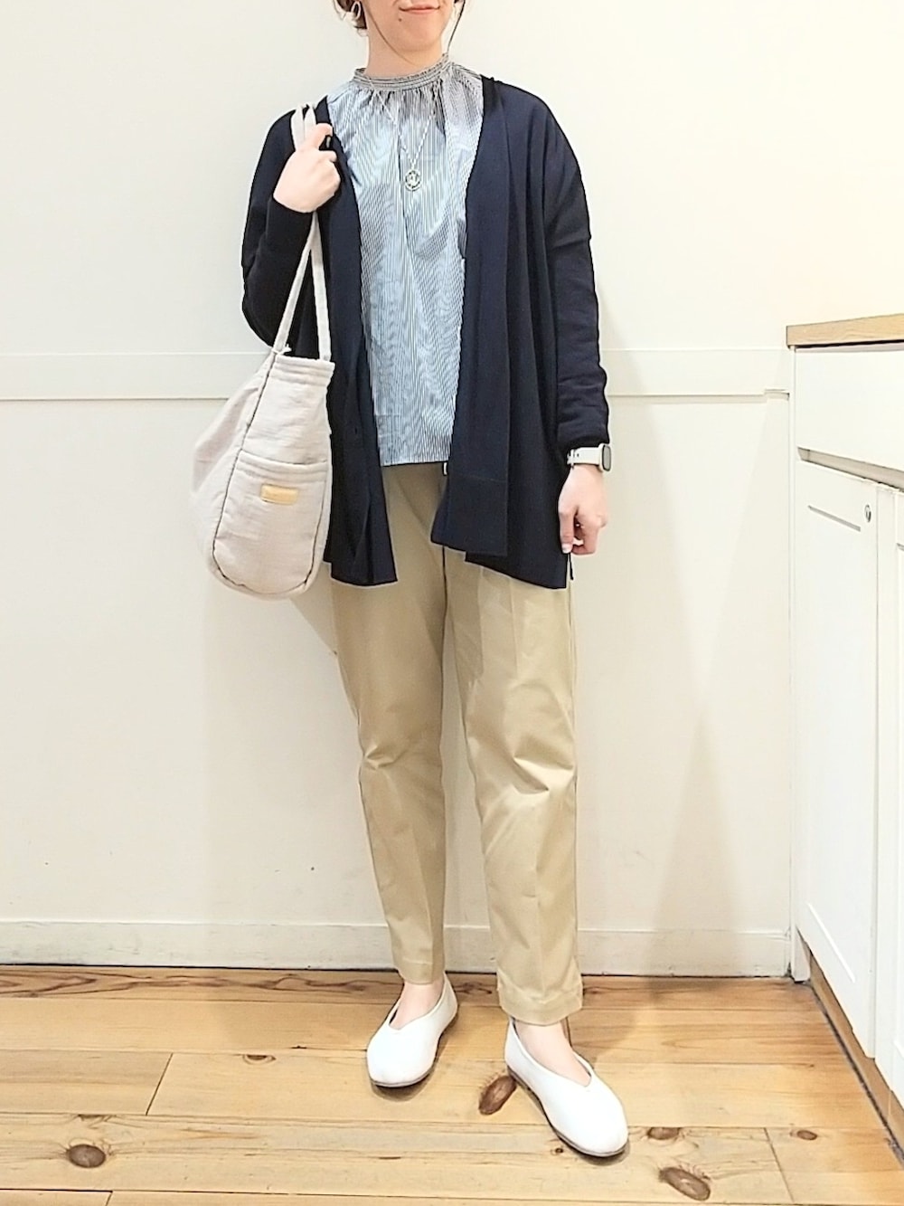 ブルー系のシャツ/ブラウス、ベージュ系のチノパンツ、ベージュ系のトートバッグを着用したレディースの春コーディネートの4枚目の写真