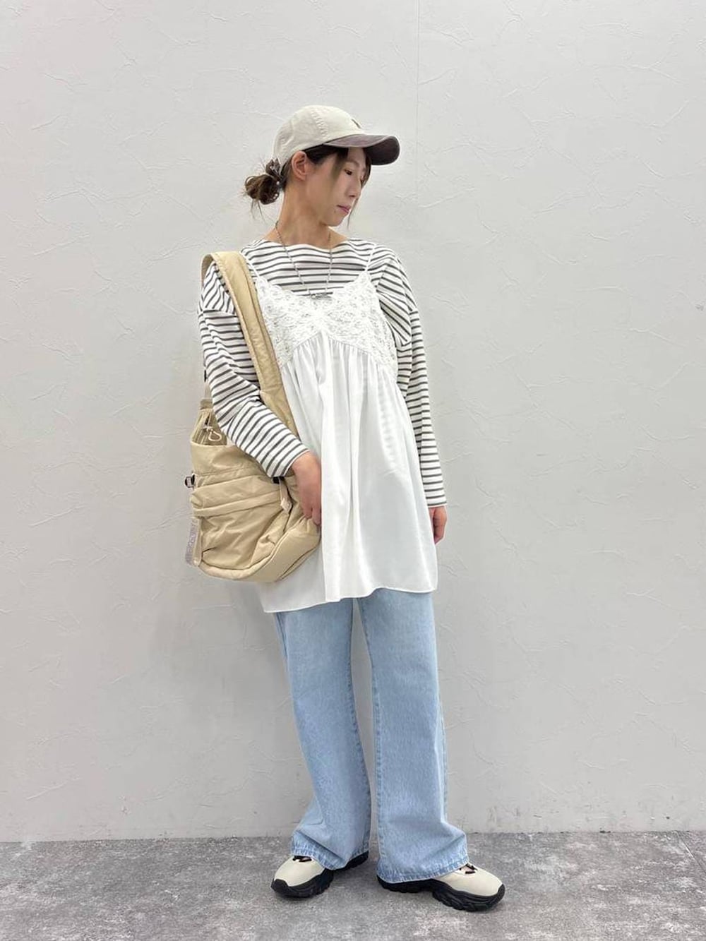 ホワイト系のスニーカー、その他のTシャツ/カットソー、ベージュ系のショルダーバッグを着用したレディースの春コーディネートの5枚目の写真