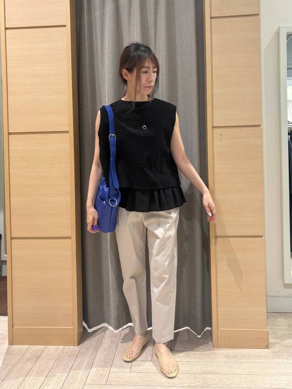 ベージュ系のその他パンツ、ベージュ系のパンプス、ブルー系のショルダーバッグを着用したレディースの夏コーディネートの4枚目の写真