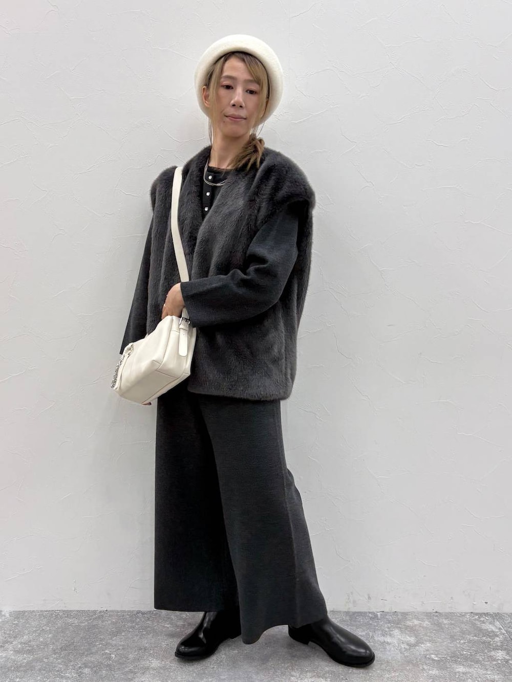 ブラック系のブーツ、ブラック系のTシャツ/カットソー、ベージュ系のショルダーバッグを着用したレディースの秋コーディネートの3枚目の写真