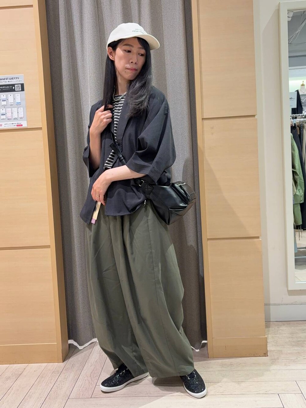 グリーン系のその他パンツ、ブラック系のその他シューズ、ブラック系のショルダーバッグを着用したレディースの秋コーディネートの2枚目の写真