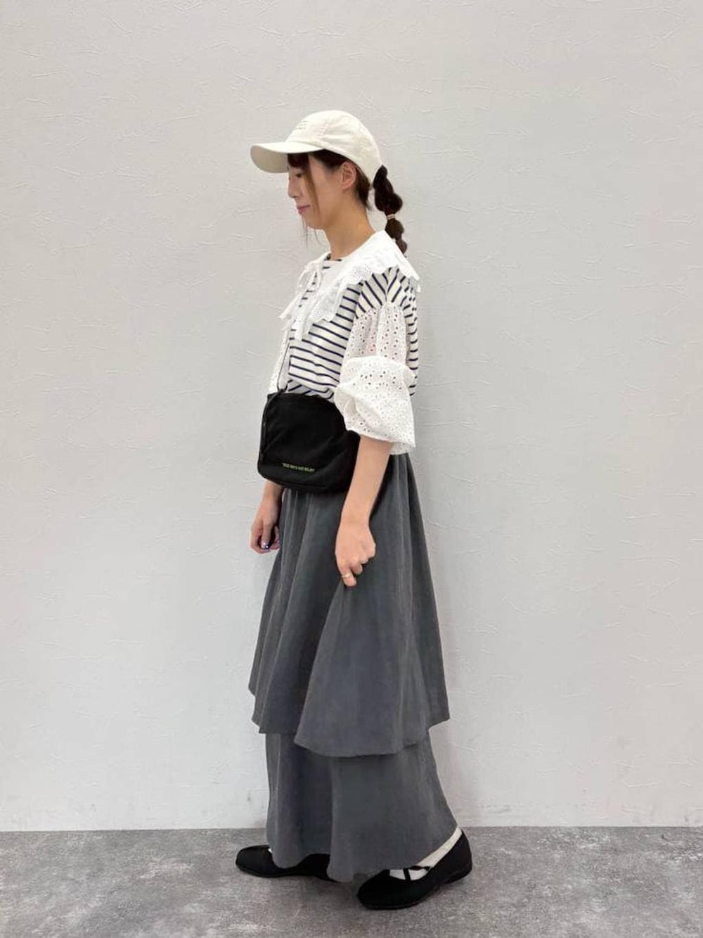 ブラック系のバレエシューズ、ブラック系のショルダーバッグ、ホワイト系のTシャツ/カットソーを着用したレディースの春コーディネートの2枚目の写真