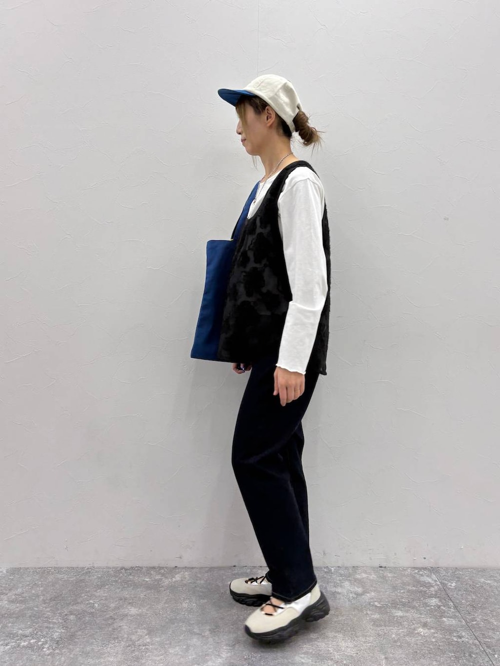 ホワイト系のスニーカー、ブラック系のTシャツ/カットソー、ブルー系のトートバッグを着用したレディースの春コーディネートの4枚目の写真