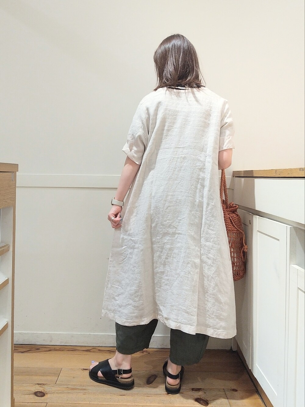 ブラック系のサンダル、ベージュ系のワンピース、ブラック系のニット/セーターを着用したレディースの夏コーディネートの2枚目の写真