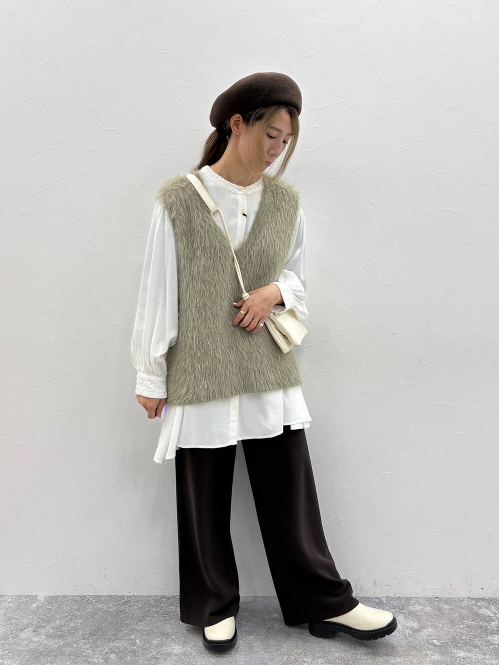 ホワイト系のシャツ/ブラウス、ベージュ系のブーツ、ブラウン系のその他パンツを着用したレディースの秋コーディネートの4枚目の写真