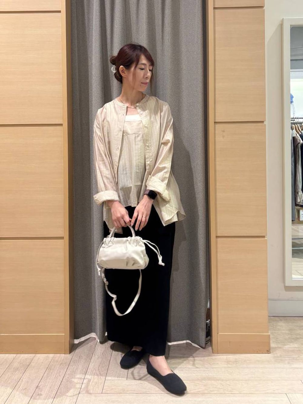 ブラック系のスカート、グレー系のパンプス、ホワイト系のタンクトップを着用したレディースの春コーディネートの4枚目の写真