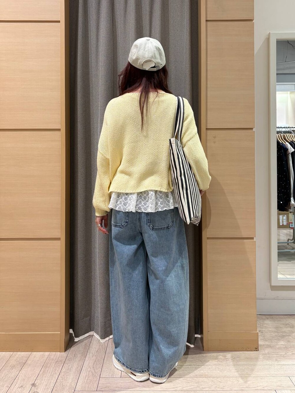 ブルー系のデニムパンツ、ホワイト系のTシャツ/カットソー、ベージュ系のトートバッグを着用したレディースの春コーディネートの5枚目の写真