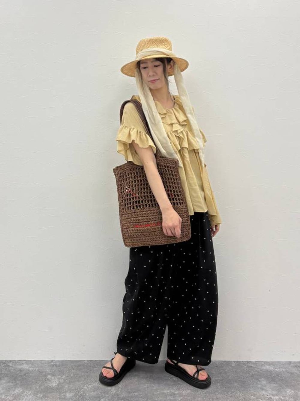 ブラウン系のトートバッグ、ブラック系のサンダル、その他のその他パンツを着用したレディースの春コーディネートの4枚目の写真