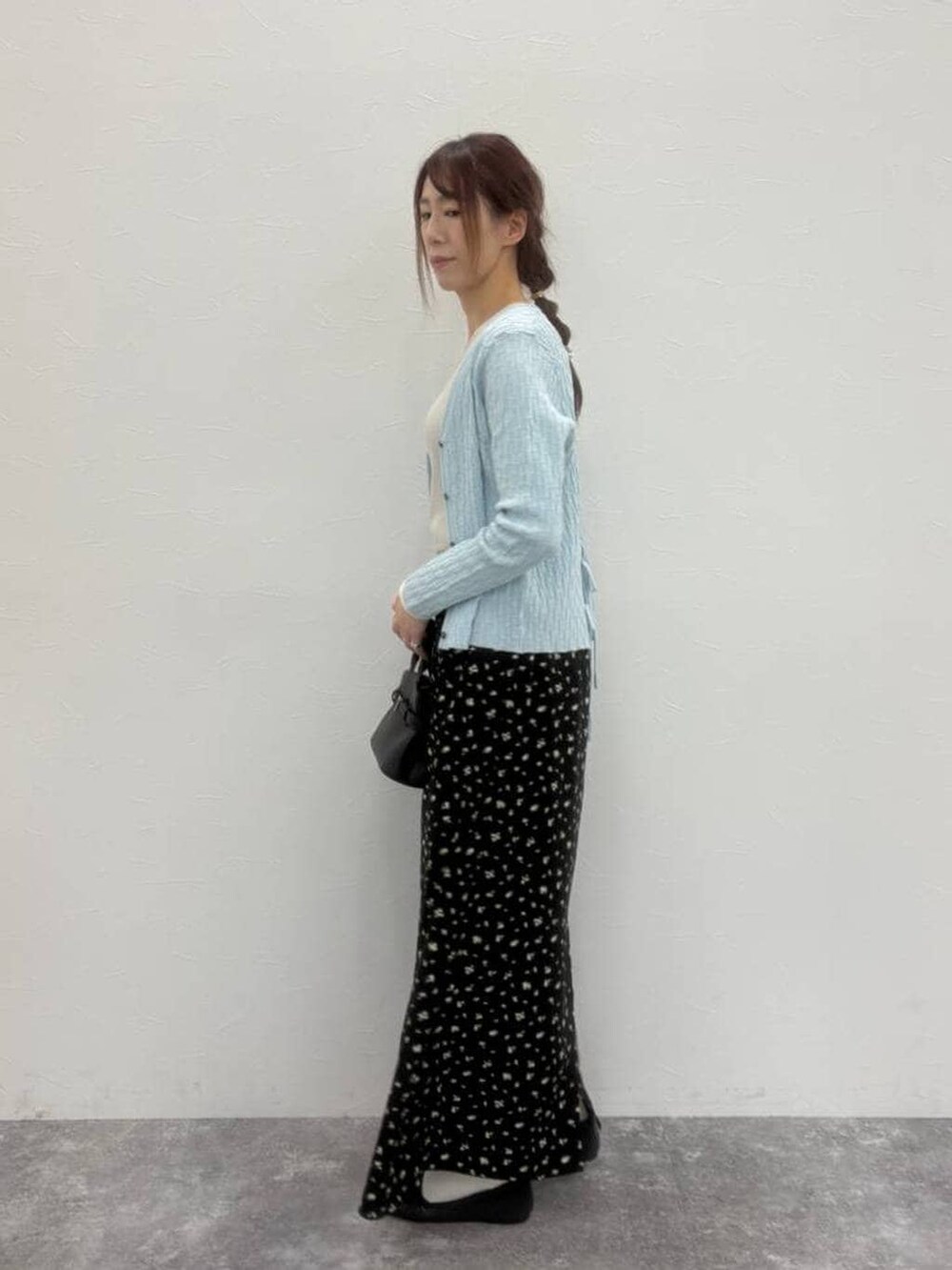 ブラック系のショルダーバッグ、グレー系のパンプス、ベージュ系のTシャツ/カットソーを着用したレディースの春コーディネートの2枚目の写真