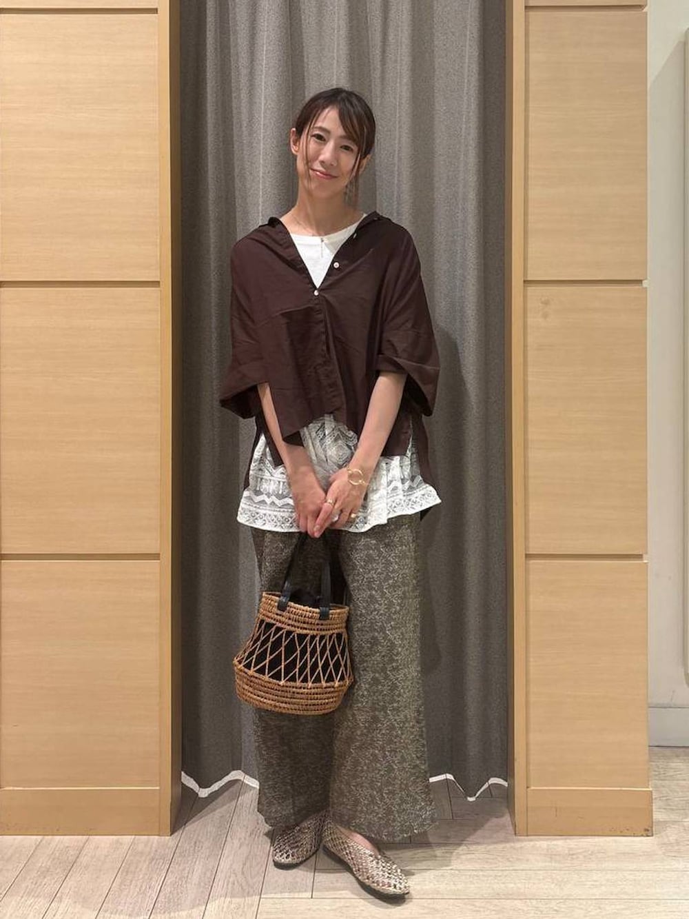ブラウン系のシャツ/ブラウス、ブラック系のトートバッグ、ゴールド系のパンプスを着用したレディースの秋コーディネートの3枚目の写真