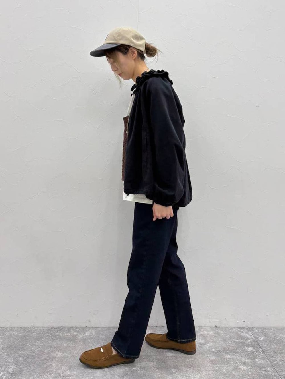 ブラウン系のベスト、ブラック系のブルゾン、ベージュ系のTシャツ/カットソーを着用したレディースの春コーディネートの2枚目の写真