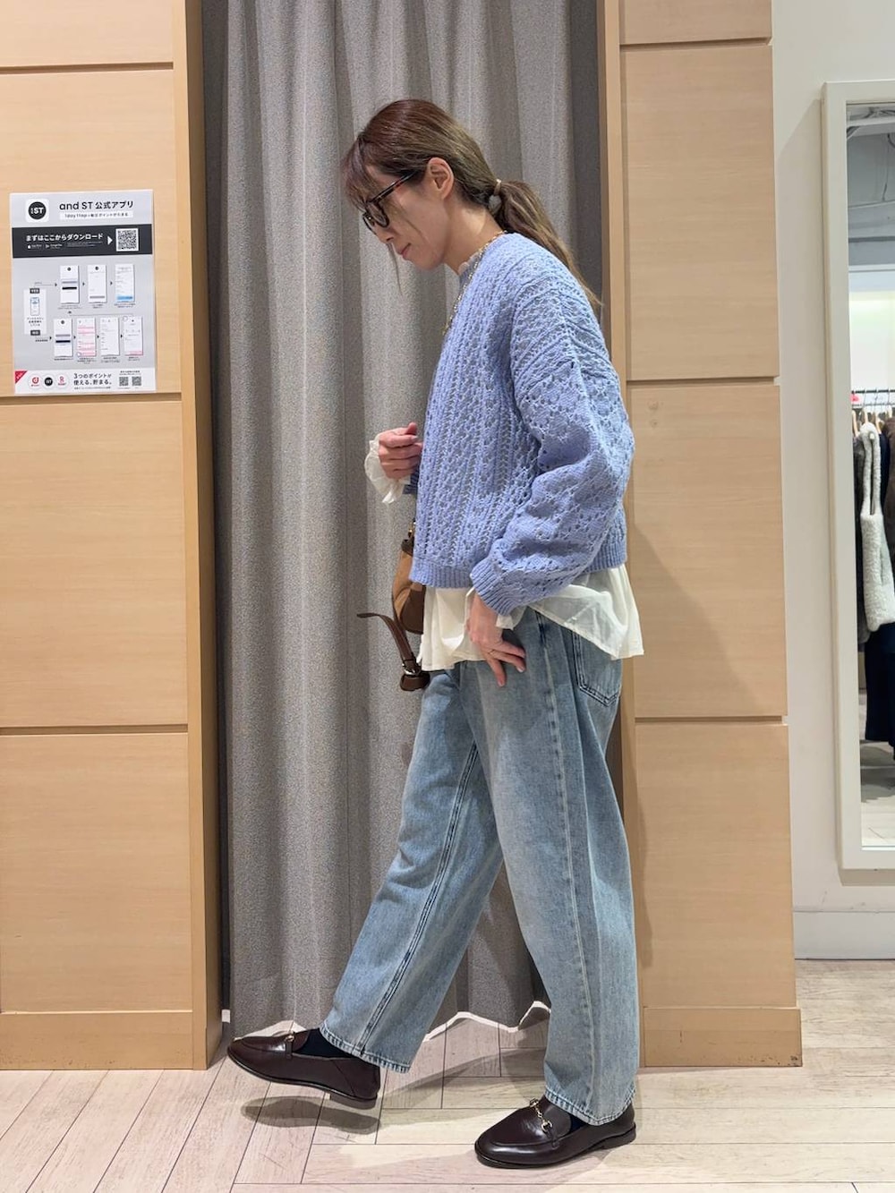 ブルー系のデニムパンツ、ブラウン系のショルダーバッグ、ホワイト系のシャツ/ブラウスを着用したレディースの春コーディネートの3枚目の写真