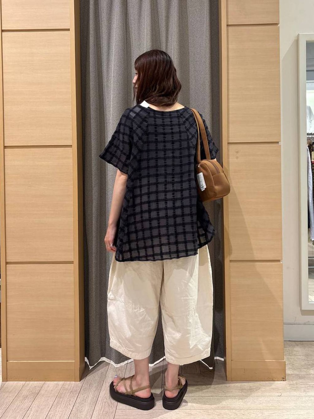 ブラウン系のショルダーバッグ、ベージュ系のサンダル、ホワイト系のその他パンツを着用したレディースの秋コーディネートの2枚目の写真
