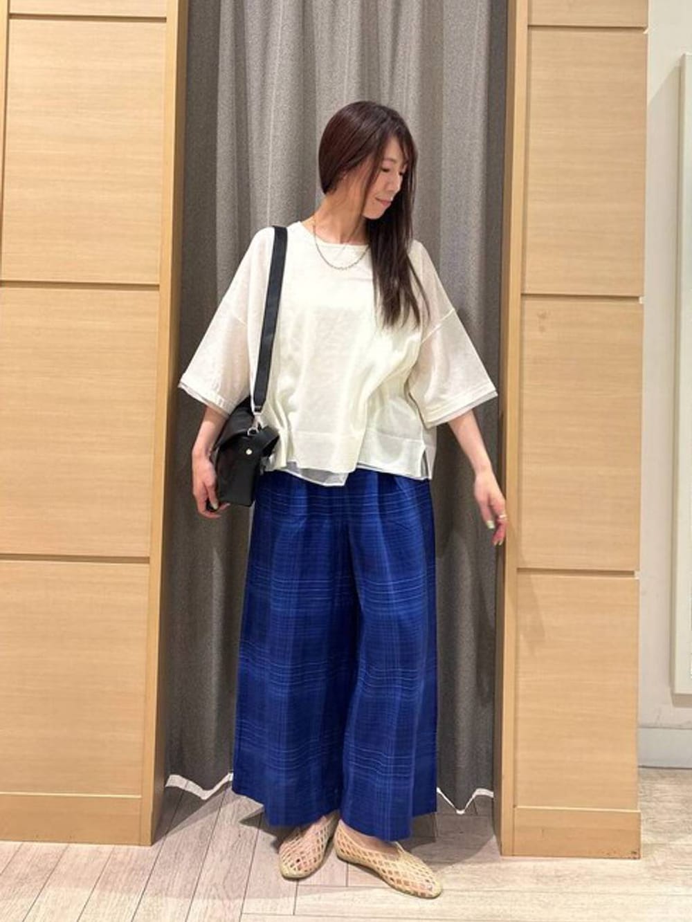 ベージュ系のパンプス、ブルー系のその他パンツ、ブラック系のショルダーバッグを着用したレディースの夏コーディネートの4枚目の写真