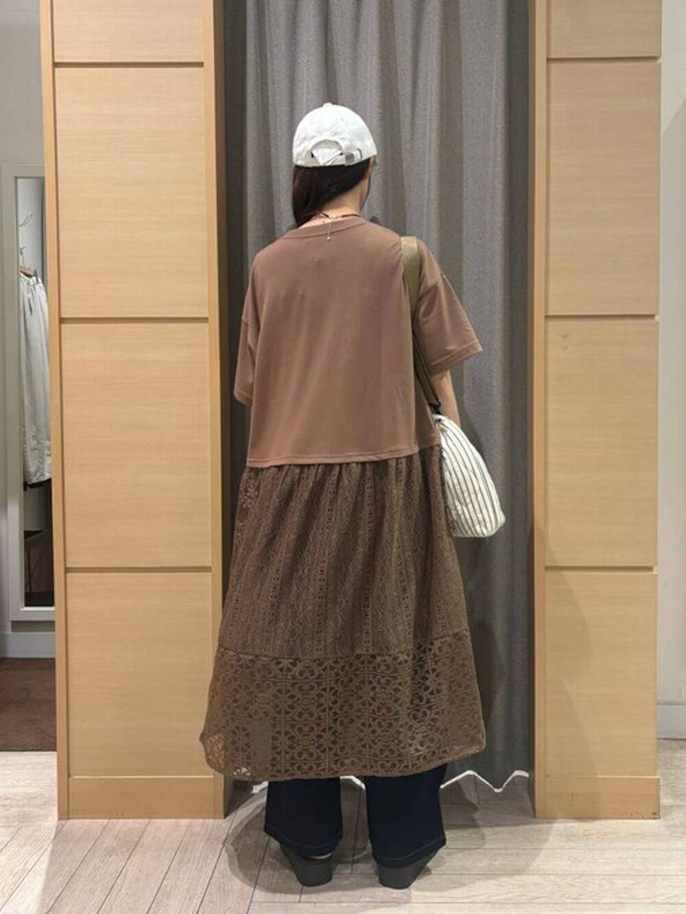 ベージュ系のショルダーバッグ、ブラウン系のサンダル、ブルー系のデニムパンツを着用したレディースの夏コーディネートの2枚目の写真