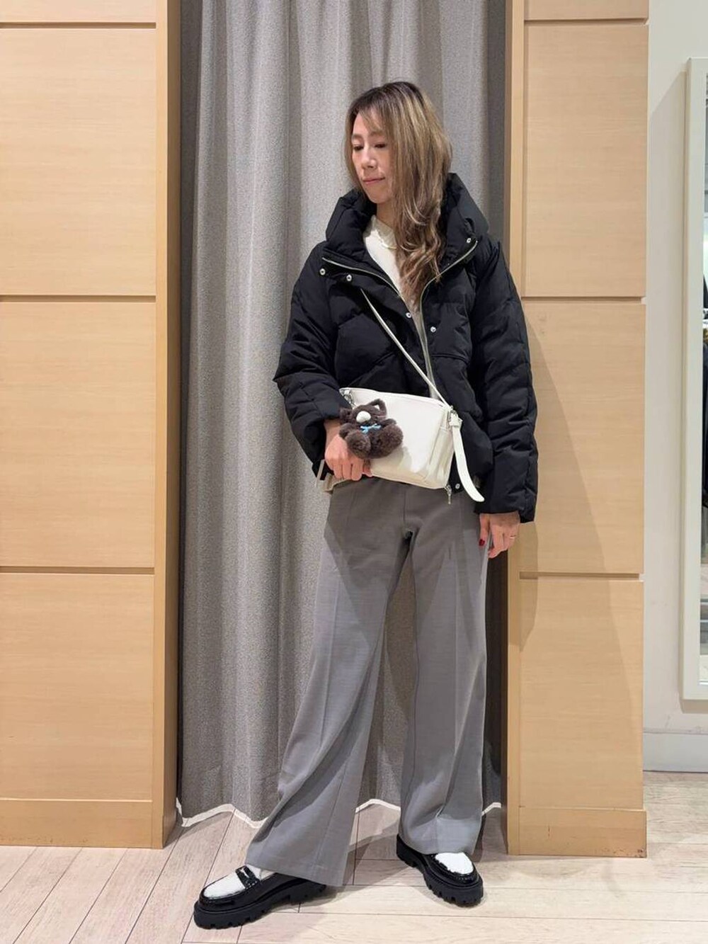 ブラック系のダウンジャケット/コート、ベージュ系のニット/セーター、ベージュ系のショルダーバッグを着用したレディースの秋コーディネートの4枚目の写真