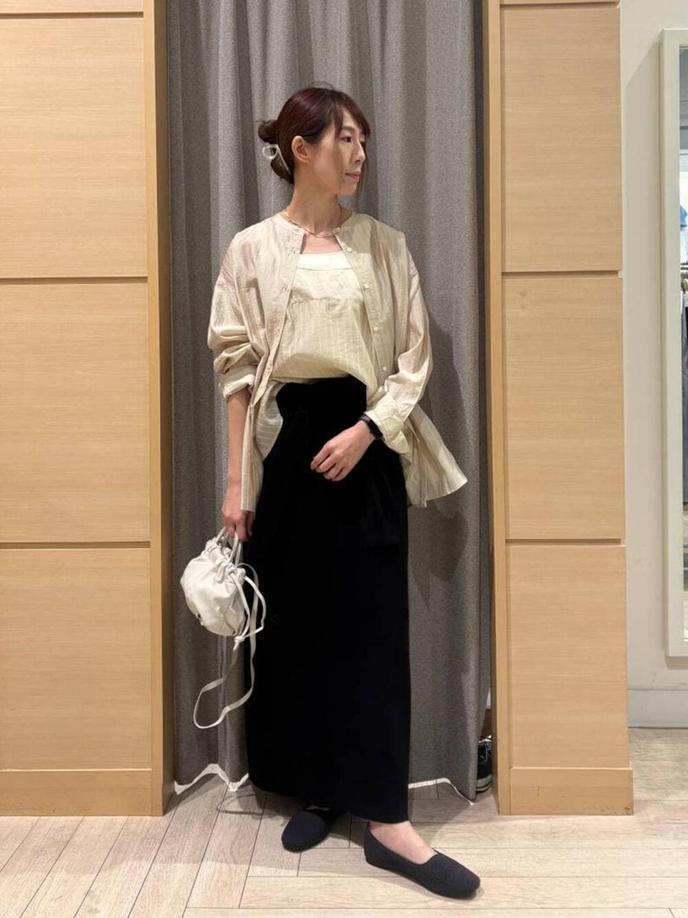 ブラック系のスカート、グレー系のパンプス、ホワイト系のタンクトップを着用したレディースの春コーディネートの5枚目の写真
