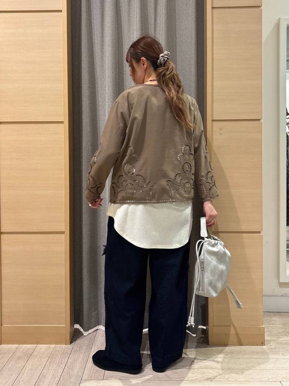 グレー系のショルダーバッグ、ブラウン系のシャツ/ブラウス、ブルー系のデニムパンツを着用したレディースの秋コーディネートの2枚目の写真