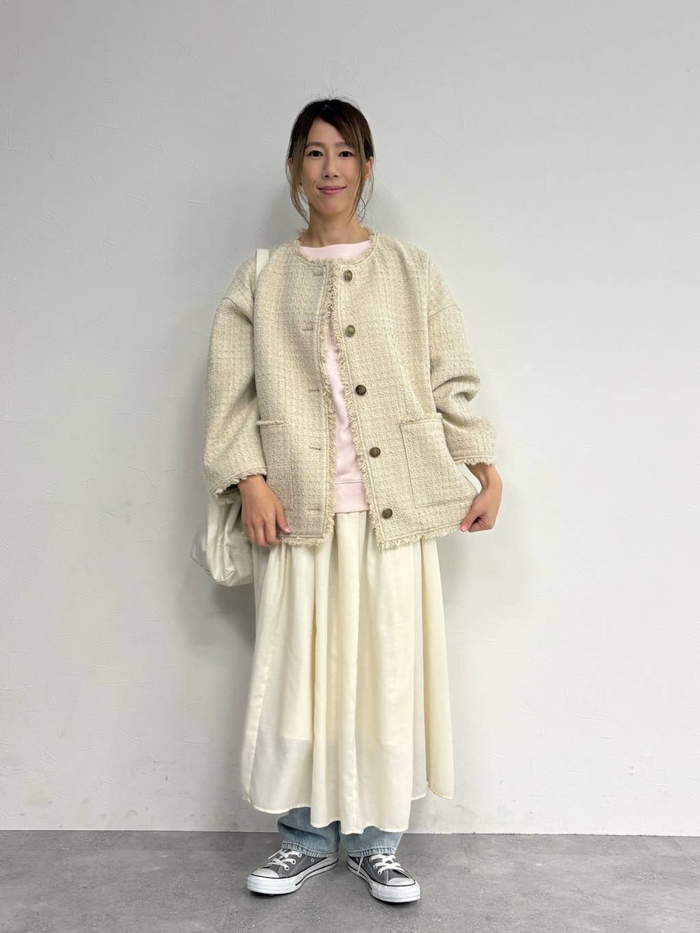 ブルー系のデニムパンツ、ベージュ系のスカート、ベージュ系のノーカラージャケットを着用したレディースの冬コーディネートの2枚目の写真