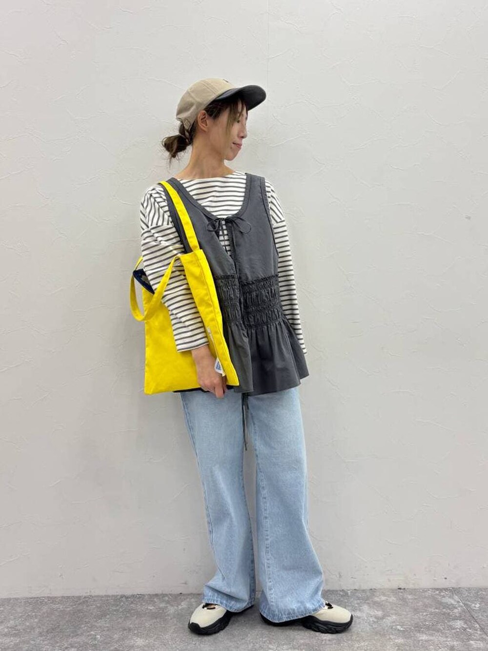 ホワイト系のスニーカー、その他のTシャツ/カットソー、イエロー系のトートバッグを着用したレディースの春コーディネートの2枚目の写真