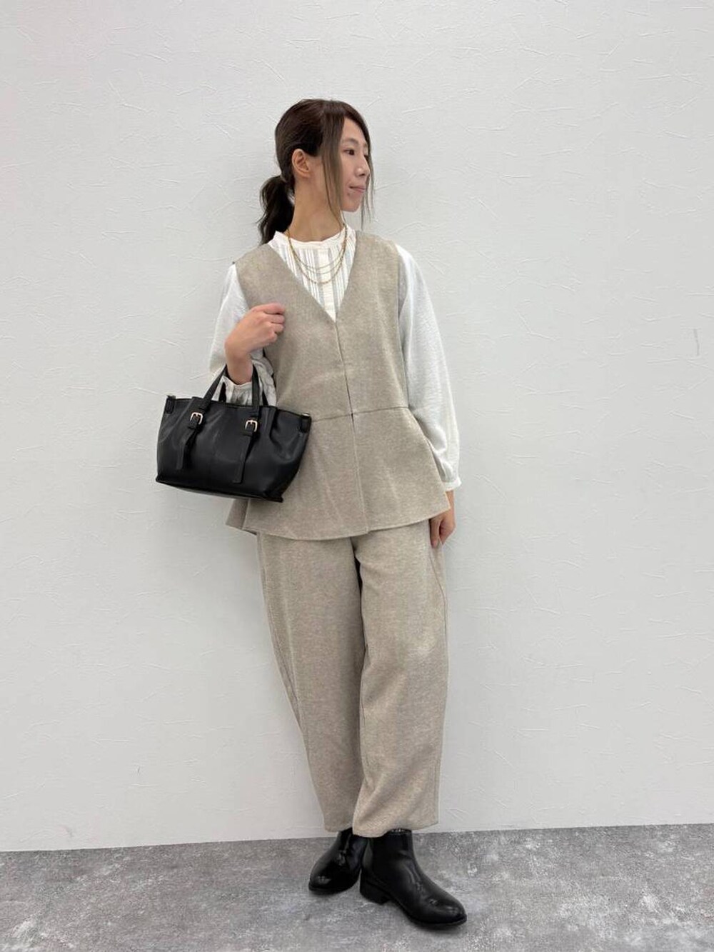 ホワイト系のシャツ/ブラウス、ブラック系のブーツ、ブラック系のショルダーバッグを着用したレディースの冬コーディネートの4枚目の写真