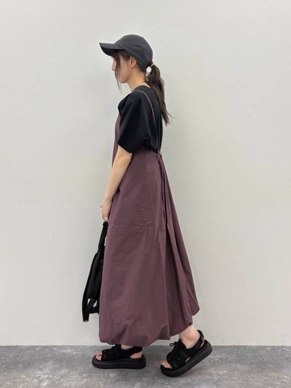 ブラック系のサンダル、ブラック系のTシャツ/カットソー、ブラック系のショルダーバッグを着用したレディースの夏コーディネートの2枚目の写真
