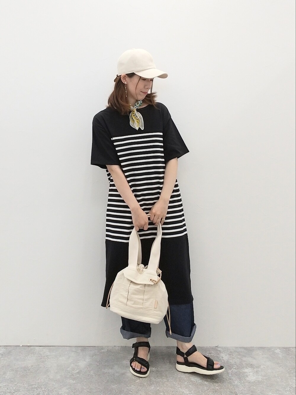 ブラック系のワンピース、ブルー系のデニムパンツ、ブラック系のサンダルを着用したレディースの夏コーディネートの2枚目の写真