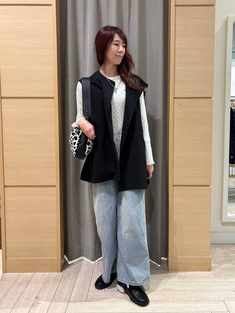 ブルー系のデニムパンツ、ブラック系のスニーカー、ホワイト系のTシャツ/カットソーを着用したレディースの春コーディネートの4枚目の写真