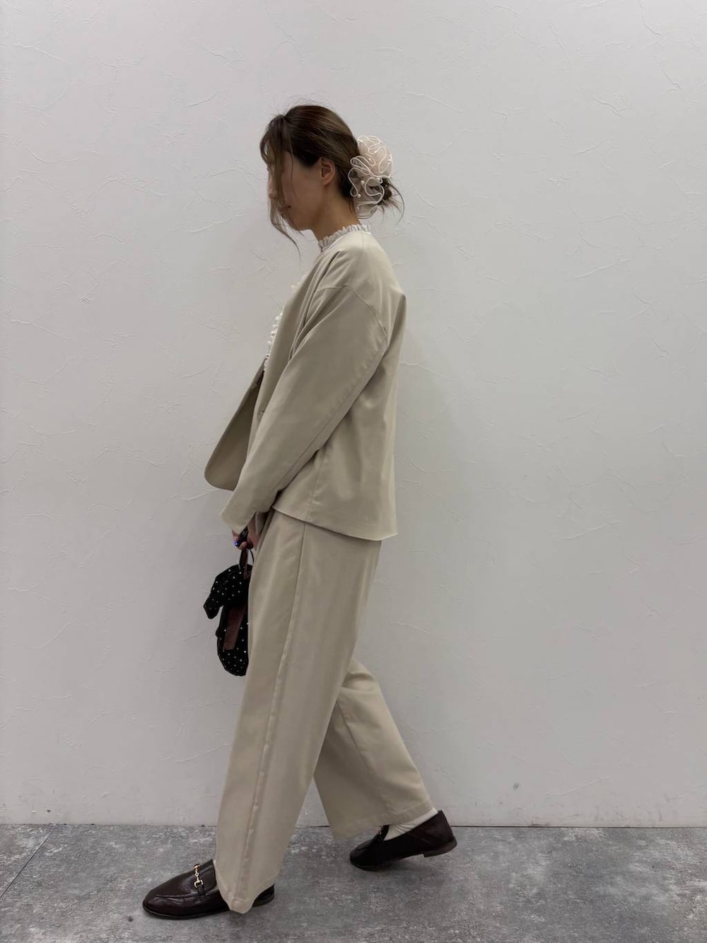 ベージュ系のスラックス、ベージュ系のノーカラージャケット、ホワイト系のシャツ/ブラウスを着用したレディースの冬コーディネートの4枚目の写真