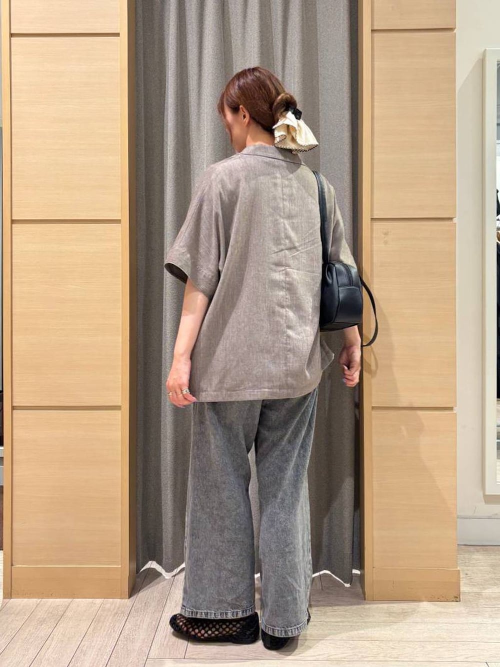 ブラック系のショルダーバッグ、ブラウン系のTシャツ/カットソー、ブラウン系のテーラードジャケットを着用したレディースの秋コーディネートの2枚目の写真