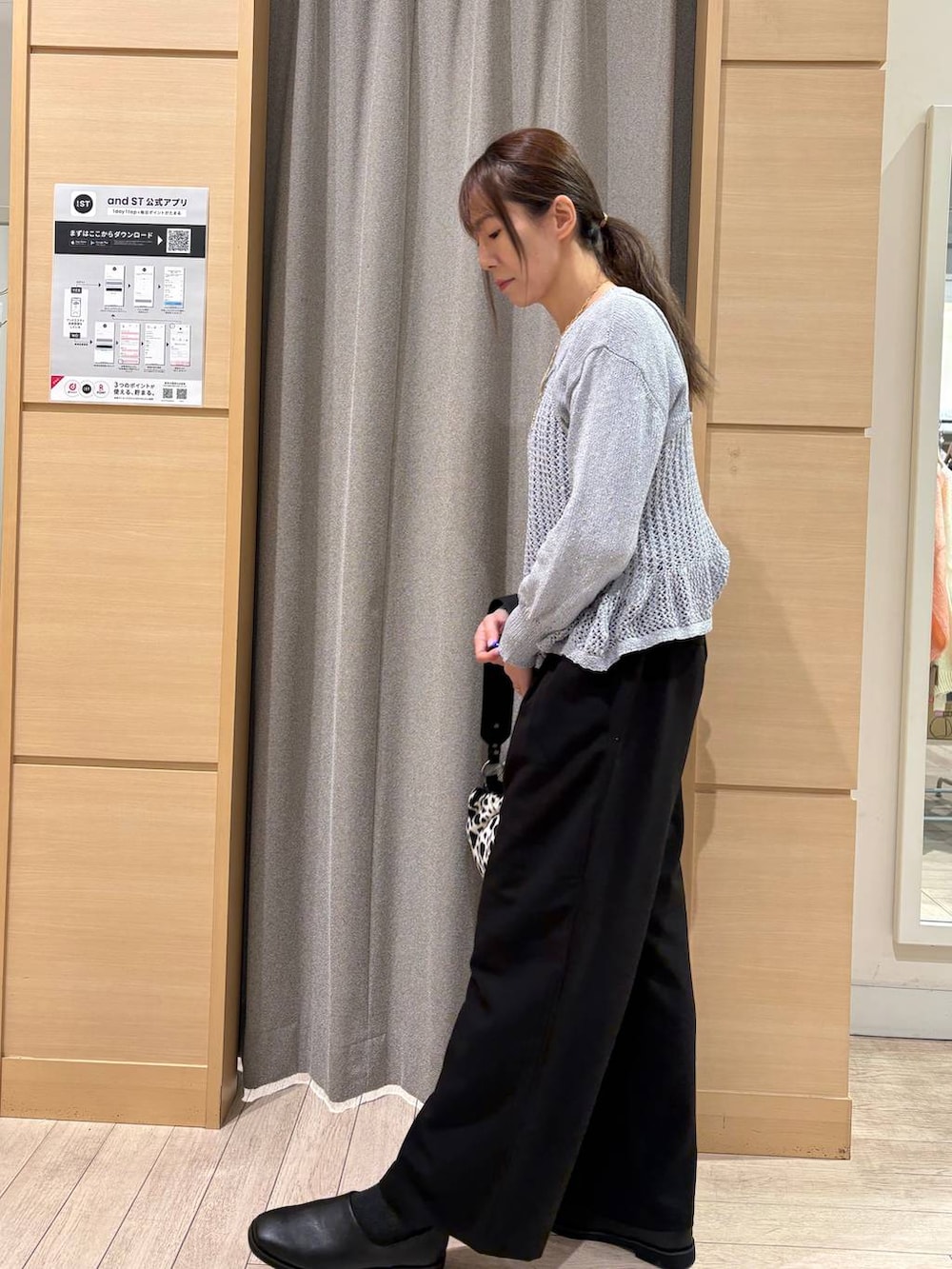 ブラック系のスラックス、その他のトートバッグ、ブルー系のニット/セーターを着用したレディースの冬コーディネートの2枚目の写真