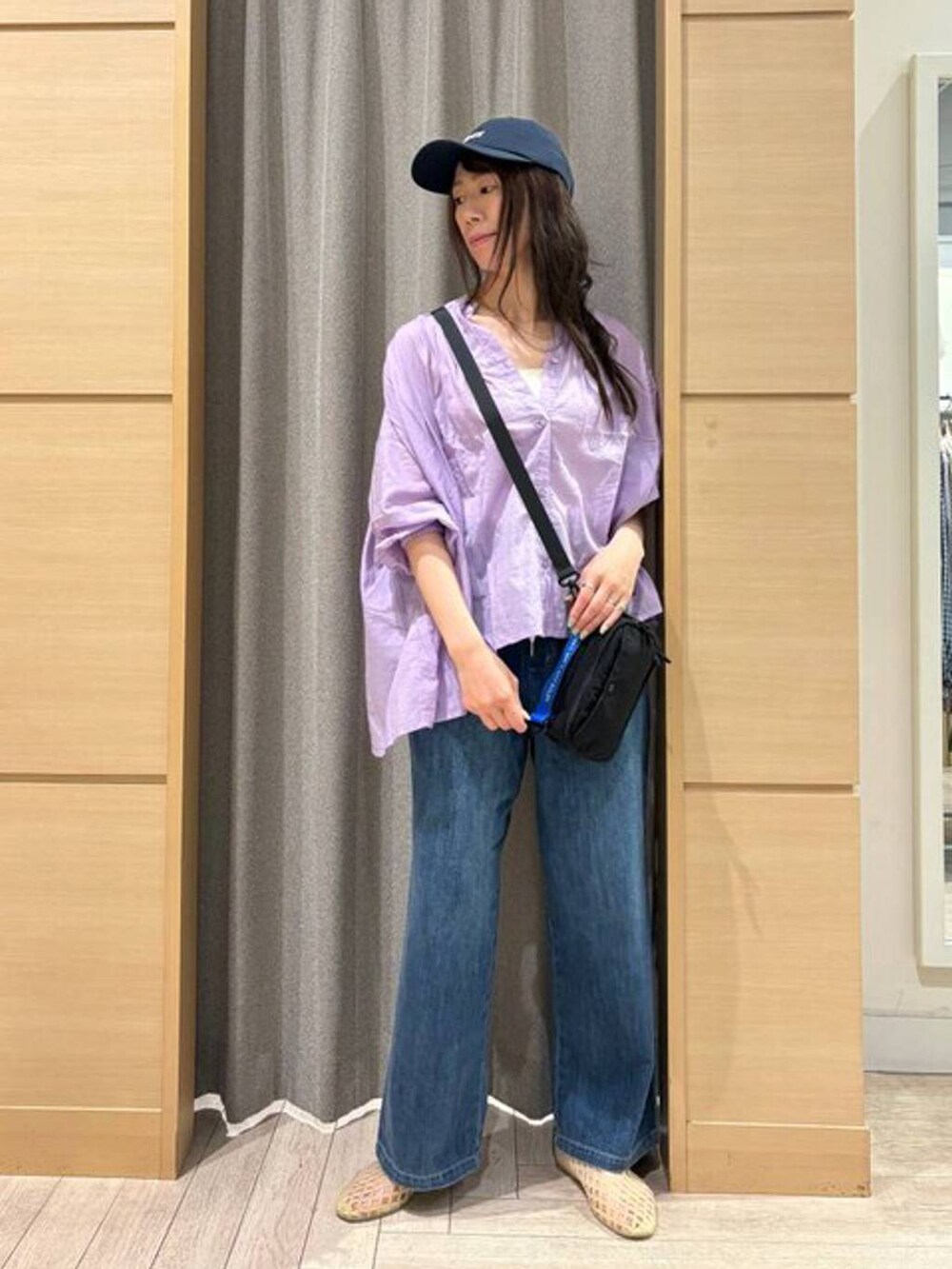 ブルー系のデニムパンツ、ホワイト系のタンクトップ、ベージュ系のパンプスを着用したレディースの夏コーディネートの4枚目の写真
