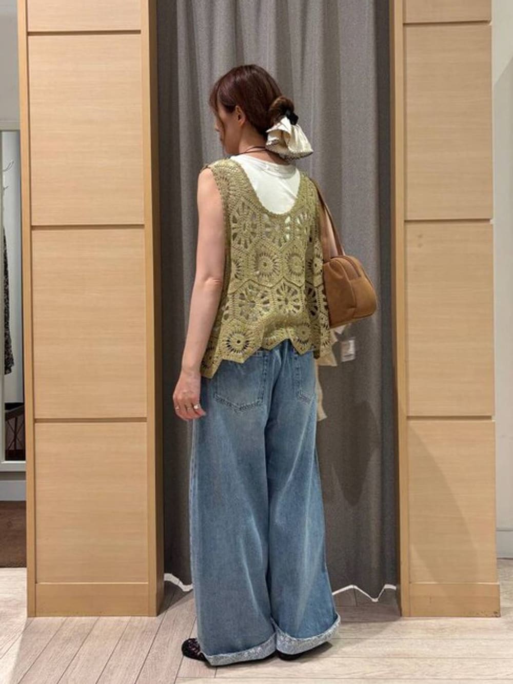 ブラウン系のショルダーバッグ、ブルー系のデニムパンツ、ベージュ系のタンクトップを着用したレディースの夏コーディネートの3枚目の写真