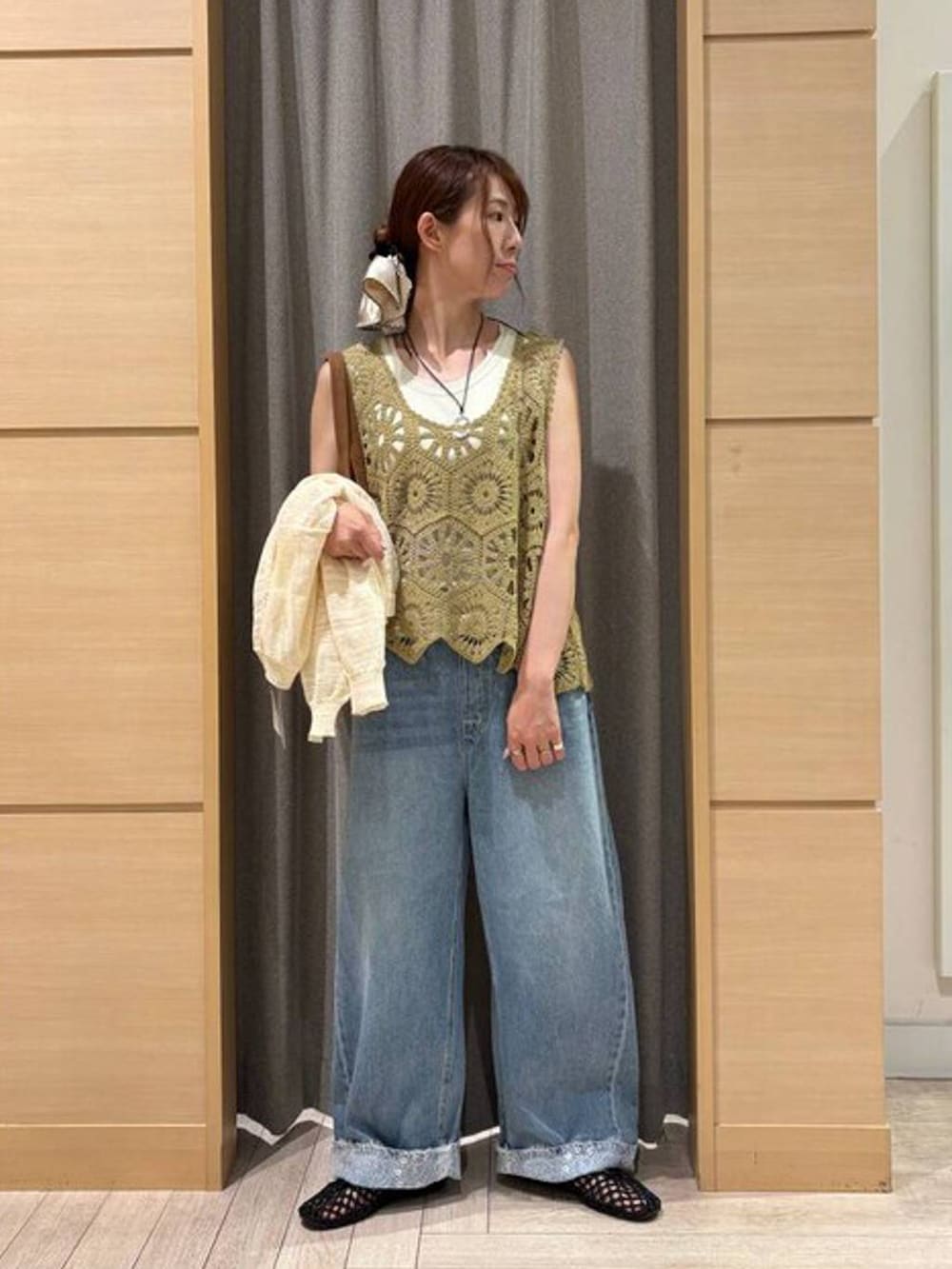 ブラウン系のショルダーバッグ、ブルー系のデニムパンツ、ベージュ系のタンクトップを着用したレディースの夏コーディネートの2枚目の写真