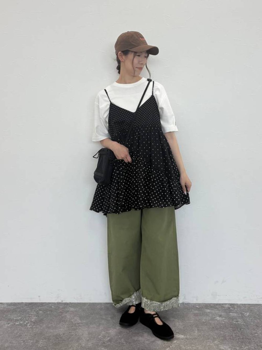 グリーン系のデニムパンツ、ホワイト系のTシャツ/カットソー、ブラック系のショルダーバッグを着用したレディースの秋コーディネートの5枚目の写真