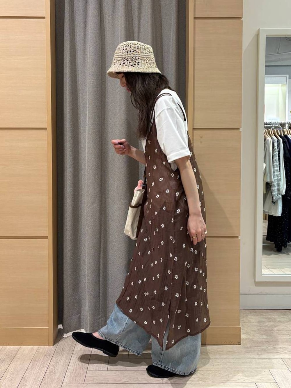 ブルー系のデニムパンツ、ベージュ系のトートバッグ、ブラック系のパンプスを着用したレディースの夏コーディネートの3枚目の写真