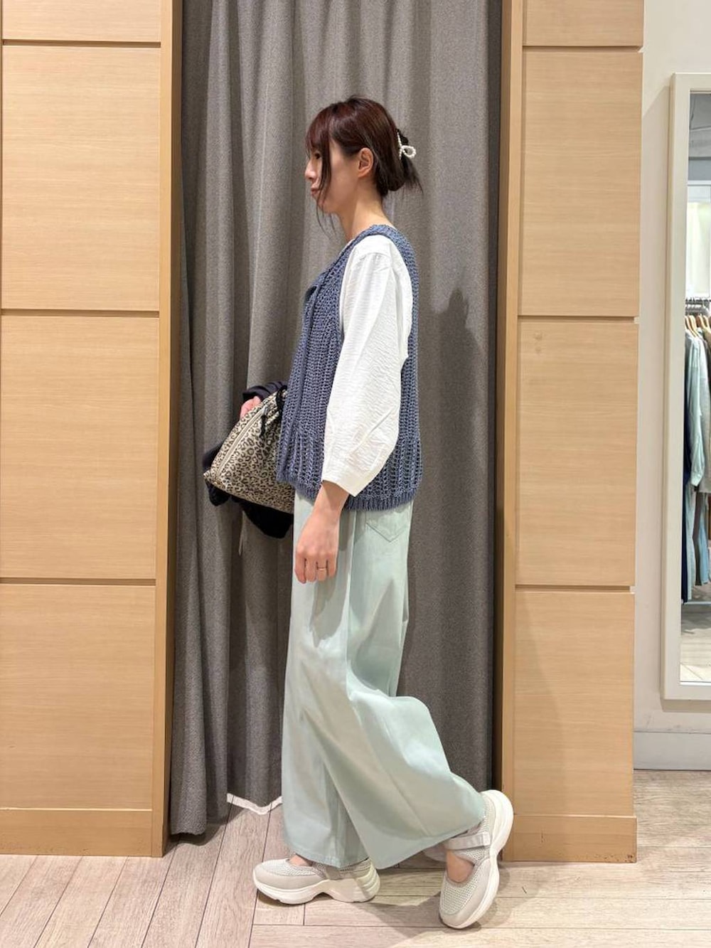 ベージュ系のショルダーバッグ、ブルー系のその他パンツ、ベージュ系のスニーカーを着用したレディースの春コーディネートの4枚目の写真