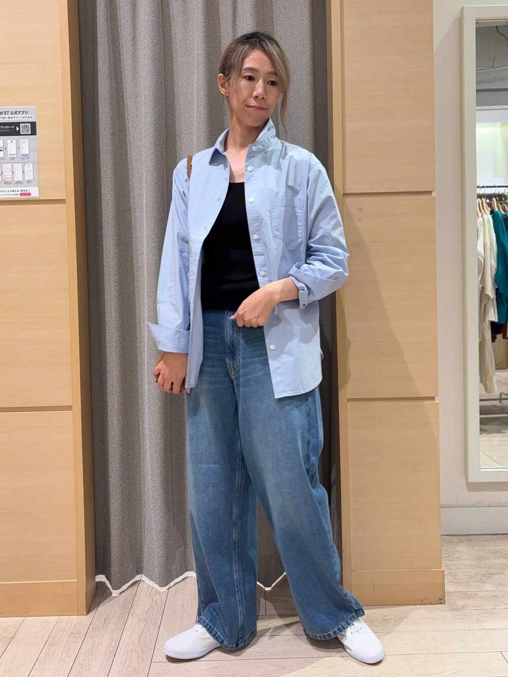 ホワイト系のスニーカー、ブラウン系のショルダーバッグ、ブルー系のデニムパンツを着用したレディースの秋コーディネートの2枚目の写真