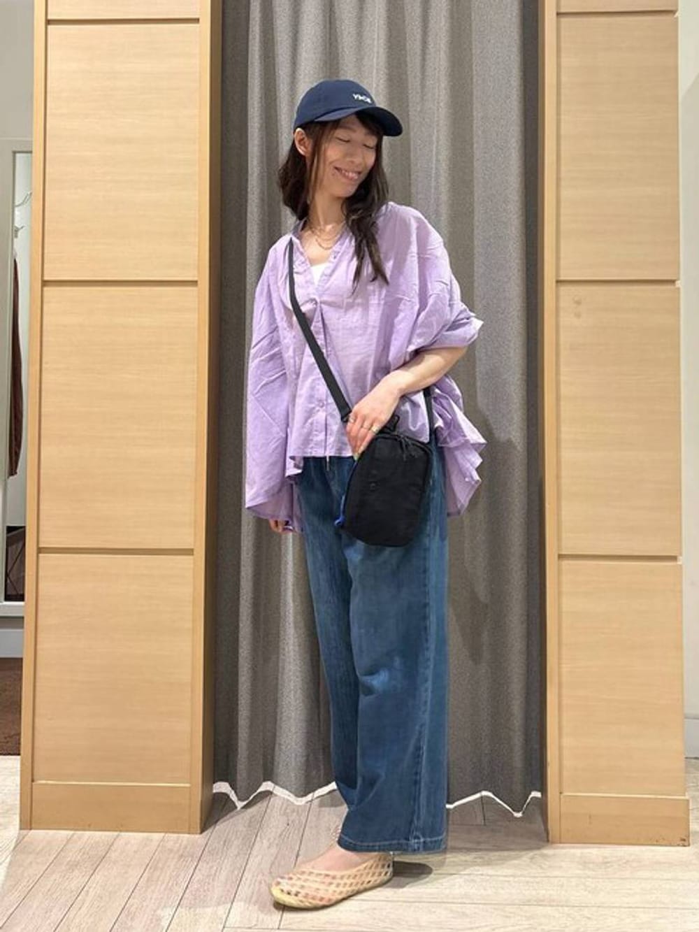 ブルー系のデニムパンツ、ホワイト系のタンクトップ、ベージュ系のパンプスを着用したレディースの夏コーディネートの2枚目の写真