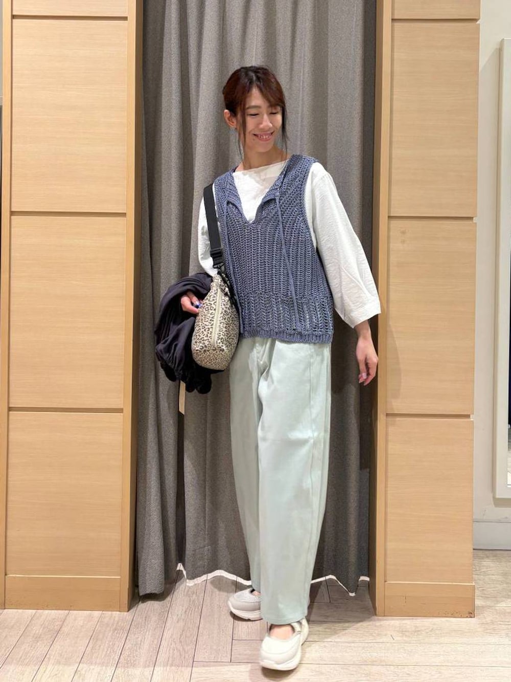 ベージュ系のショルダーバッグ、ブルー系のその他パンツ、ベージュ系のスニーカーを着用したレディースの春コーディネートの2枚目の写真